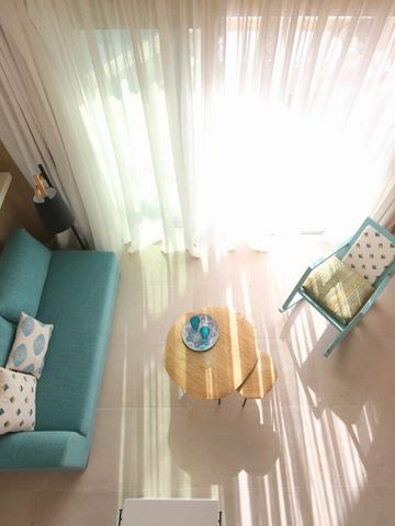 Helles Wohnzimmer mit trendigem Sofa und natürlichem Lichteinfall durch große Fenster