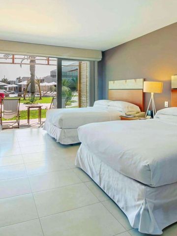 Geräumiges Gästezimmer mit zwei Betten und Terrasse mit Gartenblick