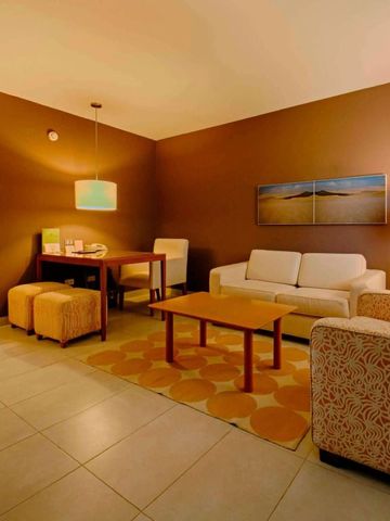 Gemütliches Wohnzimmer in warmen Erdtönen mit Sofa und Esstisch