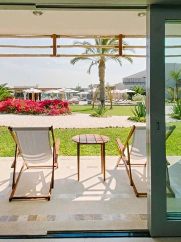 Terrasse mit Liegestühlen und Blick auf den Garten und Palmen