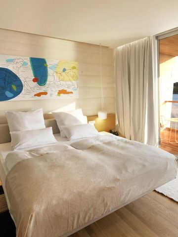 Komfortables Doppelbett in einem Zimmer mit Balkonblick im D-Resort Sibenik