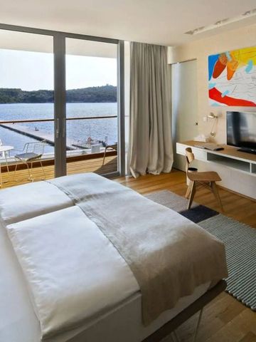 Helles Hotelzimmer mit Balkon und Blick auf das Wasser