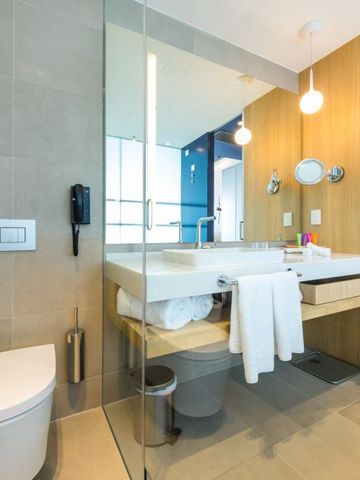 Geräumiges Badezimmer mit Glaswand und moderner Ausstattung