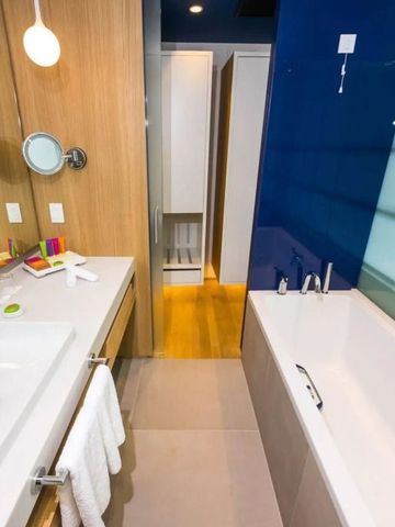 Modernes Badezimmer mit Badewanne und Holzverkleidung