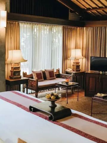 Geräumiges Zimmer mit Sitzecke und modernem TV im Resort.