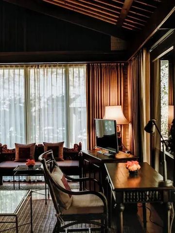 Elegant eingerichtetes Wohnzimmer mit großen Fenstern und stilvollen Dekorationen.