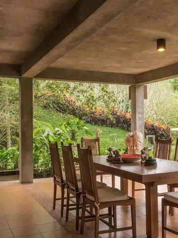 Offener Essbereich mit Holzmöbeln und Blick auf den üppigen Garten