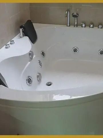 Große moderne Badewanne mit schwarzen Nackenkissen