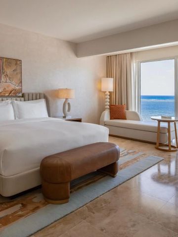 Luxuriöses Zimmer mit großem Bett, moderner Einrichtung und Meerblick