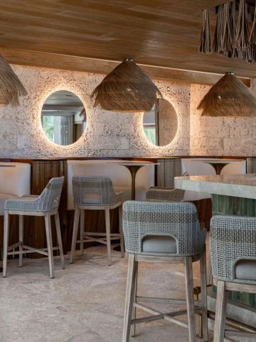 Gemütlicher Lounge-Bereich mit hölzernem Dekor und Strohlampen