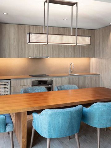 Geräumige Hotelküche mit Holztisch und blauen Stühlen im EAST Miami