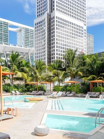 Landschaftlich gestalteter Hotelpool mit Stadtgebäuden im Hintergrund