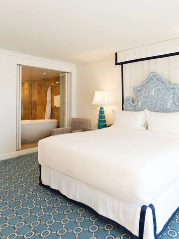 Helles Zimmer mit eleganter Einrichtung und Blick ins geräumige Badezimmer