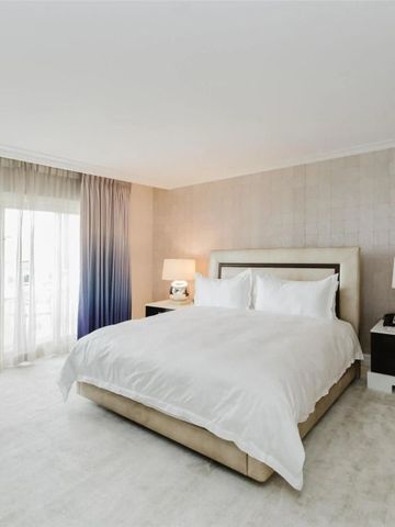 Schickes Schlafzimmer mit großen Fenstern und luxuriöser Ausstattung