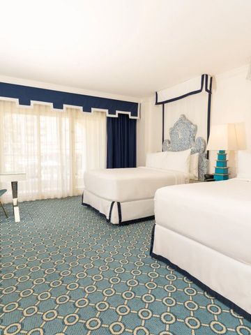 Zweibettzimmer mit blau-weißer Dekoration und großen Fenstern