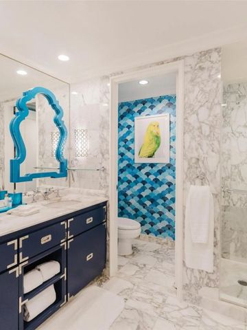 Luxuriöses Badezimmer mit blauem Akzent, Doppelwaschbecken und Marmordekor