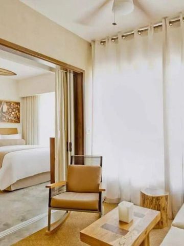 Gemütlicher Wohnbereich in der Suite mit Sesseln und Holztisch