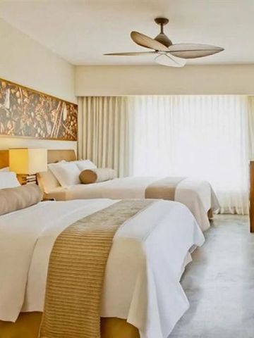 Hotelzimmer mit zwei Doppelbetten und stilvollem Dekor