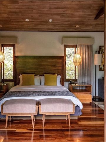 Luxuriöses Schlafzimmer mit Holzböden und großen Fenstern mit Naturblick