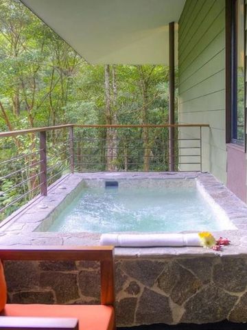 Whirlpool auf einer privaten Terrasse mit grüner Waldkulisse