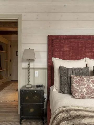 Gemütliches Schlafzimmer mit luxuriösem Bett und warmen Farbtönen in der Eleven Scarp Ridge Lodge