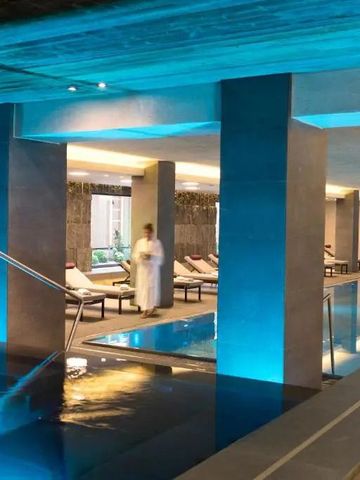 Stilvoll beleuchteter Innenpoolbereich mit Liegen und modernem Ambiente