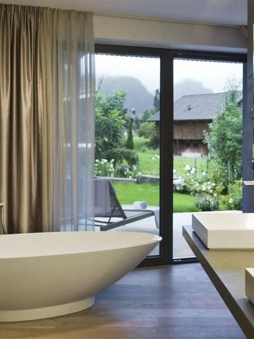 Bad mit freistehender Wanne, großem Fenster und Blick auf den Garten