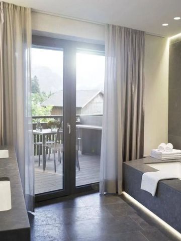 Modernes Badezimmer mit großer Badewanne und Balkonblick ins Grüne