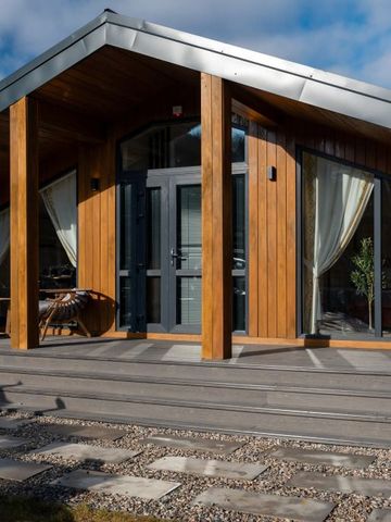 Moderne Fassade einer Villa mit Holzelementen und großen Fenstern