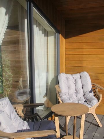 Gemütlicher Terrassenbereich mit bequemen Sitzmöbeln und Holzwand