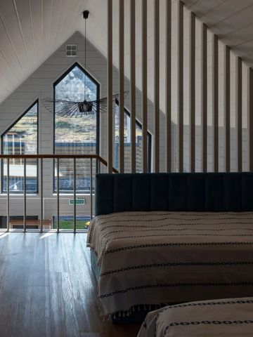 Modernes Zimmer mit großen Fenstern und Dachschrägen