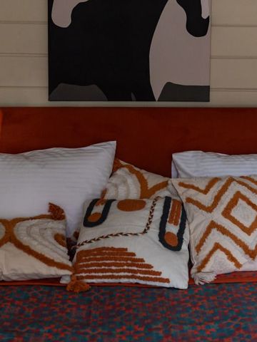 Dekoratives Bett mit orangen und weißen Kissen