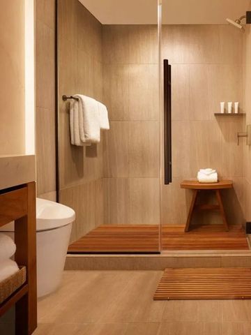 Modernes Badezimmer mit großer Dusche und edlem Holzdekor.