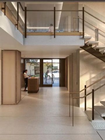 Moderne und elegante Hotellobby mit offener Treppe und viel Tageslicht