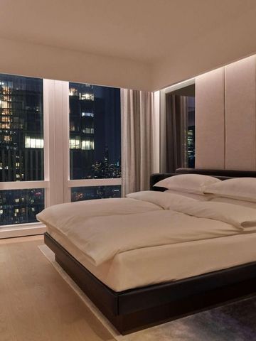 Modernes Hotelzimmer mit großem Fenster und nächtlichem Stadtblick