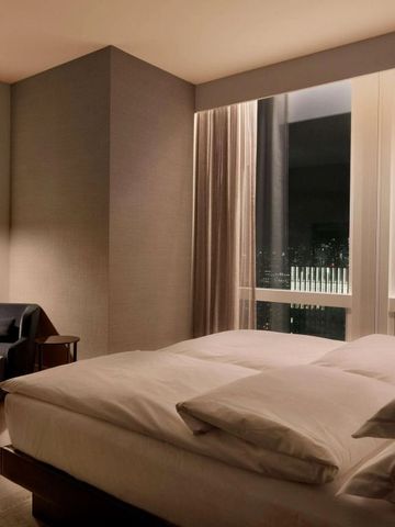 Gemütliches Hotelzimmer mit Fenster und Nachtsicht auf die Stadt