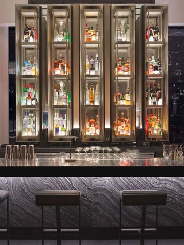 Elegante Hotelbar mit beleuchteten Spirituosenregalen und Barhockern