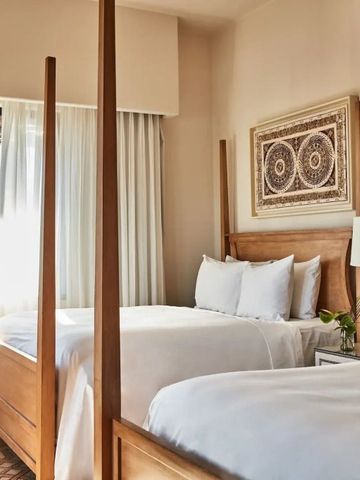 Zweibettzimmer mit hochwertiger Bettwäsche und feiner Dekoration.