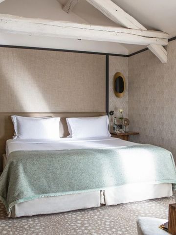 Charmantes Zimmer unter Dachbalken mit sanfter Beleuchtung und elegantem Stil.