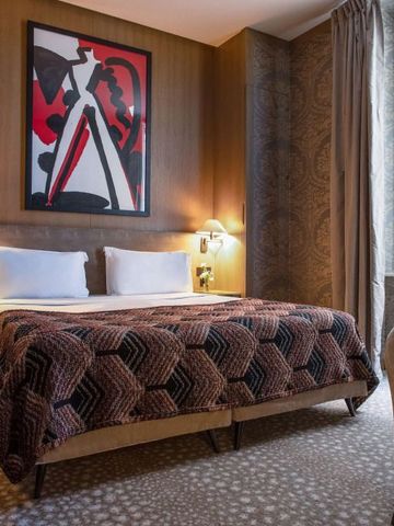 Stilvoll eingerichtetes Hotelzimmer mit moderner Kunst und luxuriösem Ambiente.