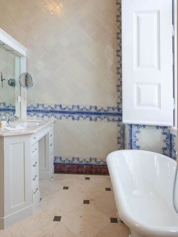 Elegantes Badezimmer mit freistehender Badewanne und kunstvollen Fliesen.