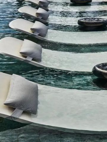 Schwimmende Liegen mit Kissen in einem luxuriösen Pool