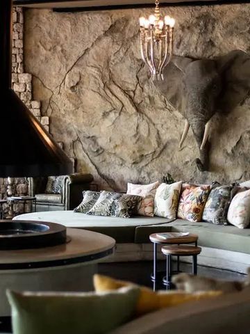 Gemütliche Lounge mit Elefantenwanddekoration und luxuriösem Kamin