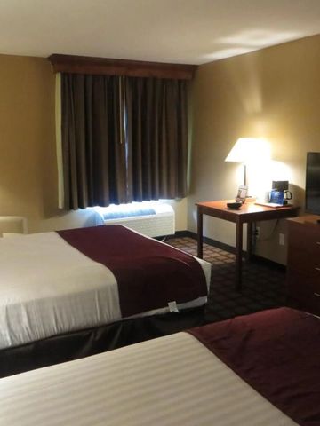 Doppelzimmer mit zwei Betten und Fernseher in neutralen Farben