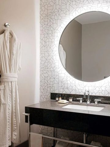 Luxuriöses Badezimmer mit beleuchtetem Spiegel und Bademantel