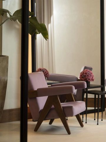 Eleganter Sitzbereich mit lila Sesseln und großen Pflanzen