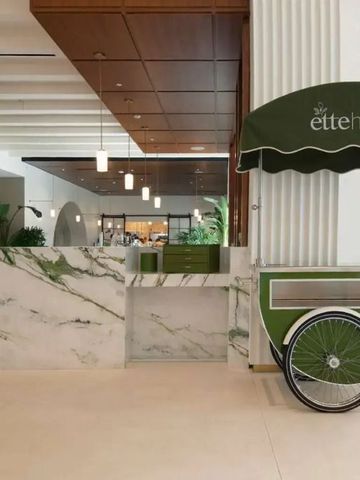 Lobby mit Marmorrezeption und grünem Dekorwagen