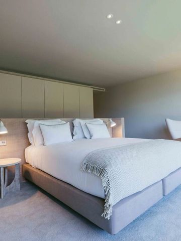 Hotelzimmer im Octant Douro mit großer Fensterfront und gemütlicher Beleuchtung