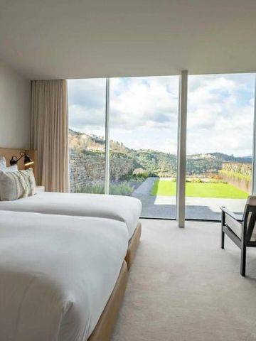 Helles Zimmer mit zwei Betten und Panoramafenster mit Blick auf die Landschaft