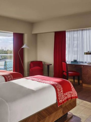 Zweibettzimmer mit Schreibtisch und großen Fenstern